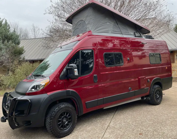 This bright red pop-top RV rental features off-road tires and a front bull bar for adventure.. Winnebago Solis 2021