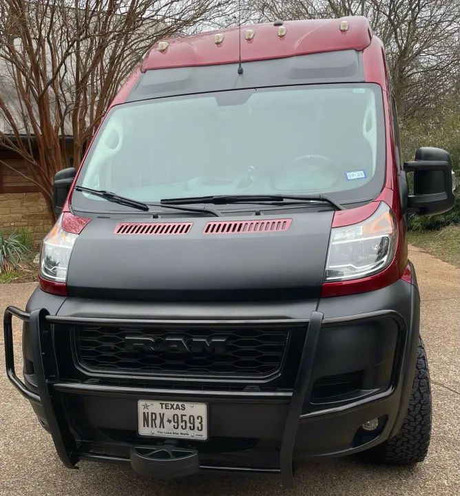Front view of a rugged maroon and black Ram ProMaster van, perfect for your next RV rental adventure.. Winnebago Solis 2021