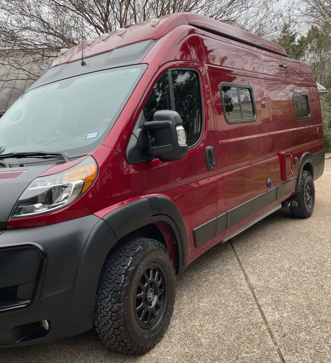 This vibrant red camper van, equipped with off-road tires, is ideal for an RV rental adventure on the open road.. Winnebago Solis 2021