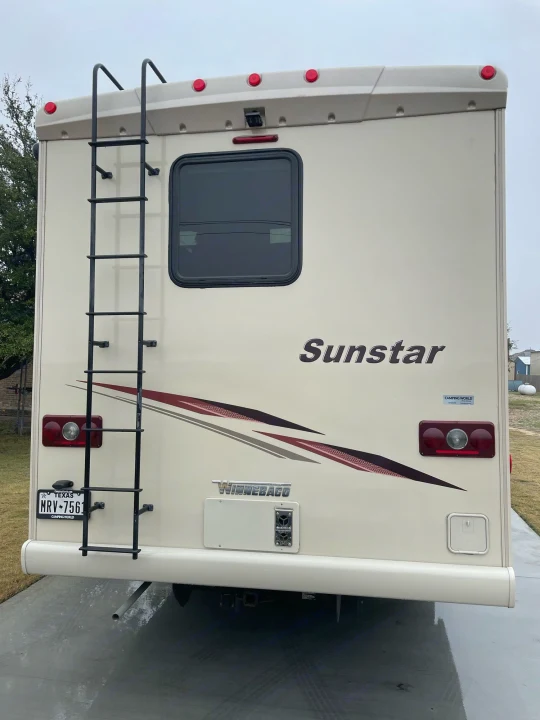 Rear view of an RV rental, a cream Winnebago Sunstar, with a ladder & TX license plate. Perfect for your next adventure!. Winnebago Sightseer 2019