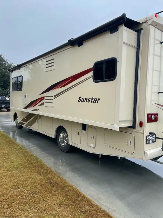 Spacious Sunstar RV, ideal for your next rv rental adventure. Parked on a wet driveway with slide-out extended.. Winnebago Sightseer 2019