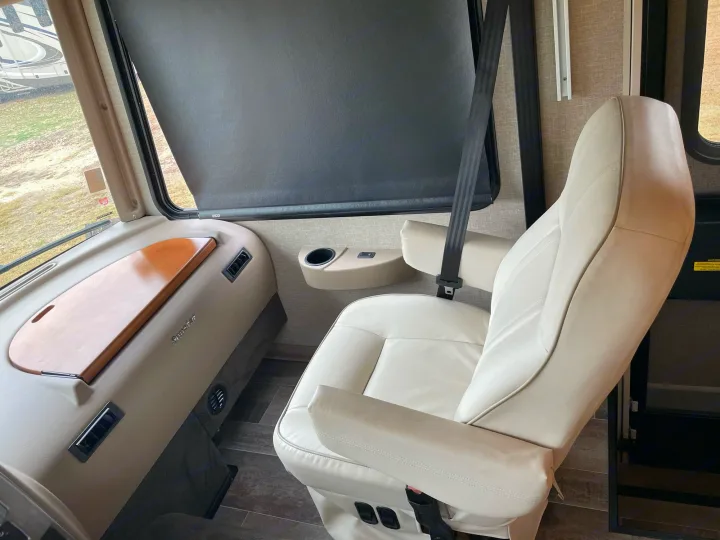Spacious & comfortable RV rental driver's cockpit with plush seat, dash, and window. Ready for your journey!. Winnebago Sightseer 2019