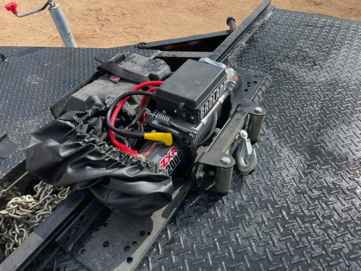 Badland ZXR 2000 winch, battery, and cables on a trailer deck. Great for RV rental towing or recovery.. Big Tex 20" Flatbed 2014