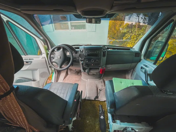 Inside an RV rental camper van, revealing the cockpit, dashboard, and front seats from a rear perspective.. Mercedes-Benz sprinter 2008