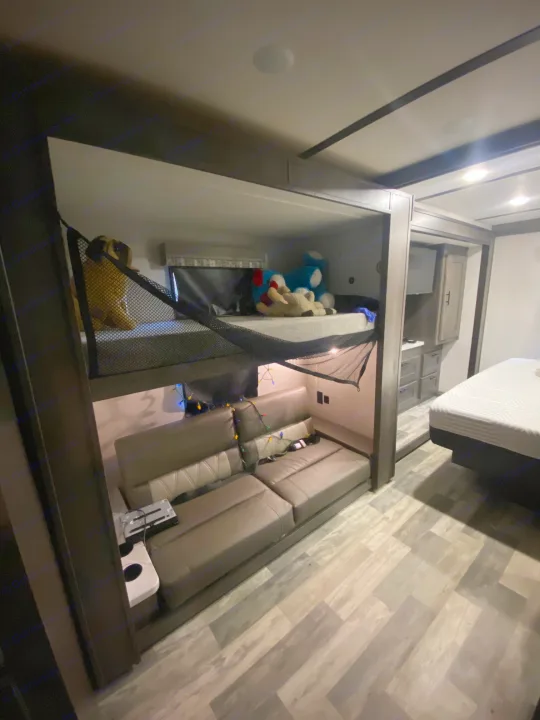 Spacious RV rental interior: bunk beds with toys, large sofa, and built-in cabinets. Modern and comfortable multi-level design.. Forest River Other 2021