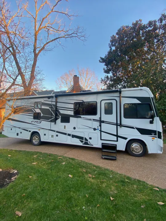 A clean, white and black Forest River FR3 motorhome is parked on a driveway under a blue sky, perfect for RV rental.. Forest River Other 2021