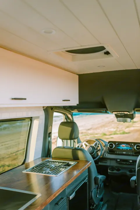 Experience an RV rental! This modern camper van features a full kitchen with stove, sink, wood counters, and driver's area.. Mercedes-Benz Sprinter 2021