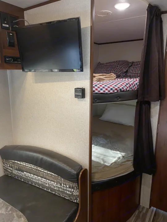 RV rental interior with a wall-mounted TV, dinette, and comfortable bunk beds, perfect for travel.. Jayco Jay Flight SLX 2017