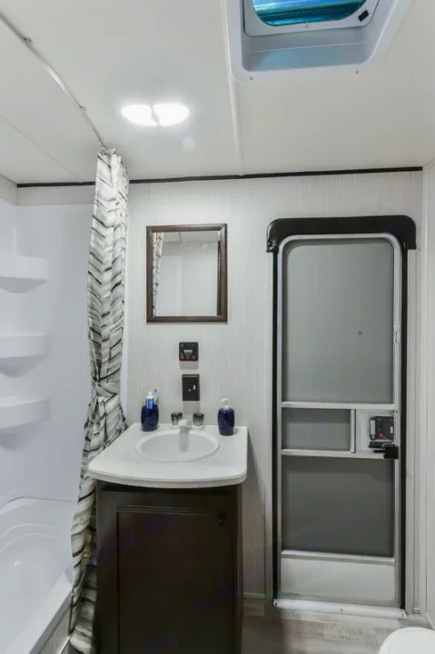 Compact RV rental bathroom featuring a sink, vanity, shower, mirror, and door, ideal for travel.. Heartland RVs Prowler 2020
