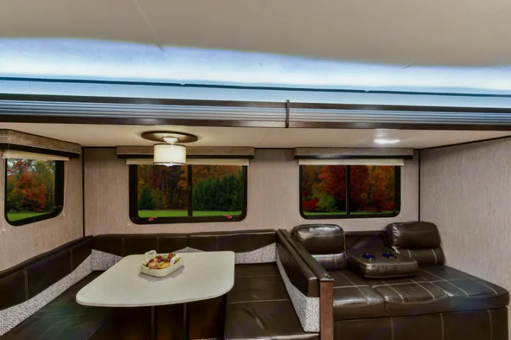 Explore comfort in this RV rental: a cozy U-shaped dinette, recliners, and windows with vibrant autumn views await your trip.. Heartland RVs Prowler 2020