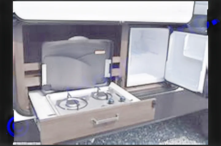 This RV rental outdoor kitchen includes a pull-out two-burner stove, portable grill, and dual mini-fridges.. Grand Design Transcend Xplor 2022