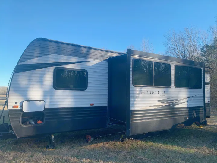 This white and grey Hideout travel trailer features an extended side slide-out. Ideal for your next RV rental adventure.. Keystone Hideout 2020