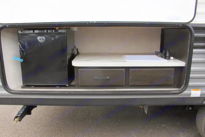 RV rental outdoor kitchen setup featuring a mini-fridge, sink, and drawers. Ideal for camping convenience.. Jayco Jay Flight SLX 224BH 2022