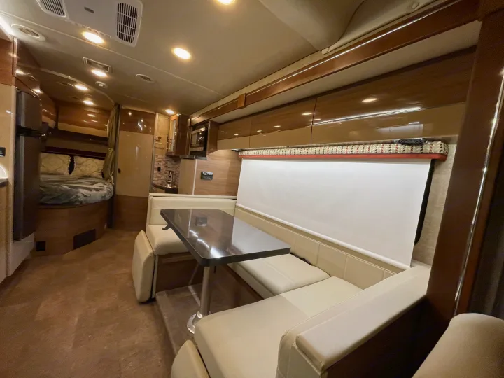 Experience comfort in this spacious RV rental, featuring a full dinette, kitchen, and cozy bedroom area.. Itasca Navion 2016