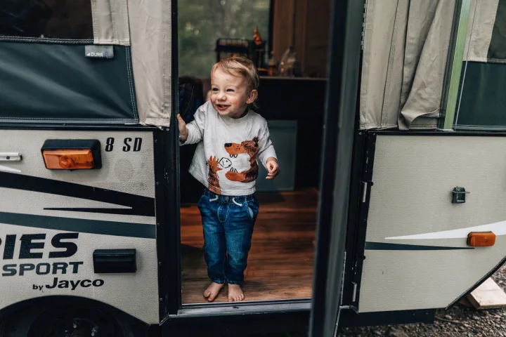 Happy toddler smiles from a Jayco Sport pop-up camper, a perfect rv rental for family adventures.. Jayco Jay 2015