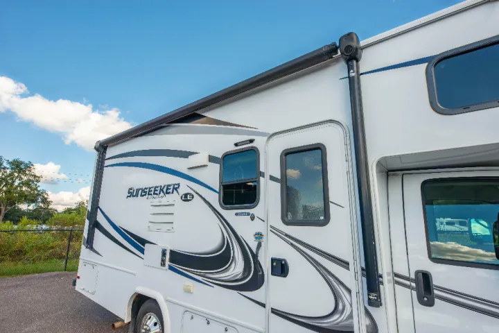 Explore in style with this Sunseeker Class C RV rental. White exterior with blue graphics, awning, and windows.. Forester LE 2018