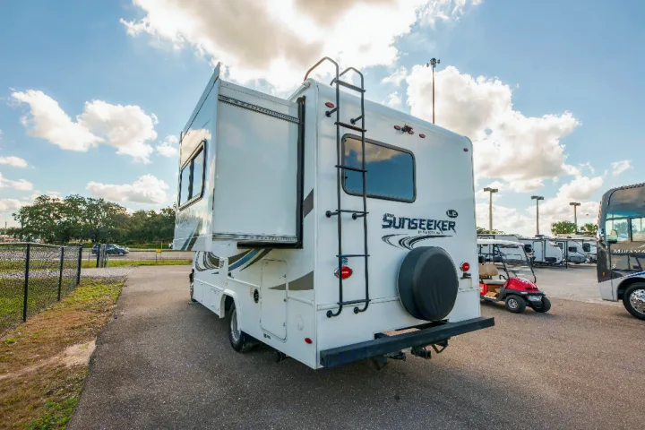 White Sunseeker rv rental with slide-out extended, parked in a sunny lot with other motorhomes for travel.. Forester LE 2018