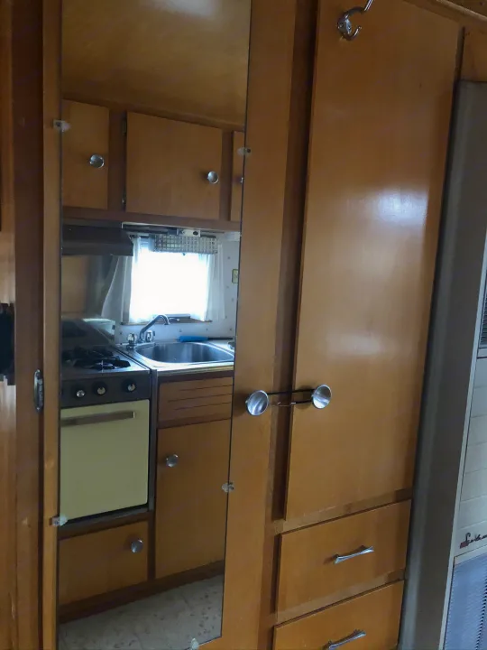 RV rental: Vintage interior featuring mirrored cabinets reflecting a compact kitchen with stove and sink.. Holiday Rambler Traveler 1964