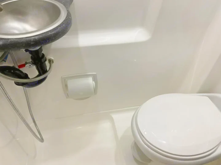RV rental's compact wet bath, featuring a sink, toilet, and toilet paper holder. An efficient, all-in-one design.. Midwest Automotive Designs Midwest Automotive Designs Class B 2020
