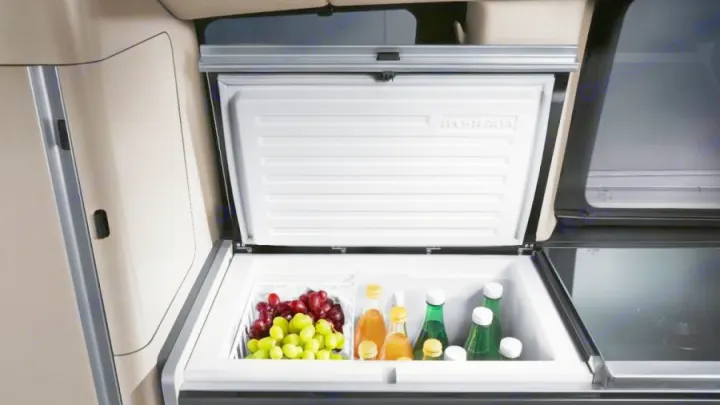 Spacious Westfalia fridge open in an RV rental, filled with fresh grapes & bottled drinks. Perfect for road trip snacks.. Mercedes Marco Polo 2022
