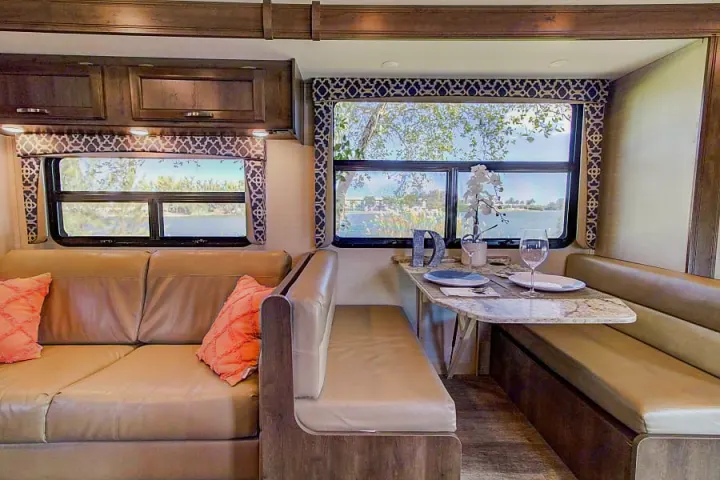Relax in this RV rental's inviting interior. Features a comfortable sofa & dinette with scenic views, ideal for travel.. Jayco Redhawk 2018