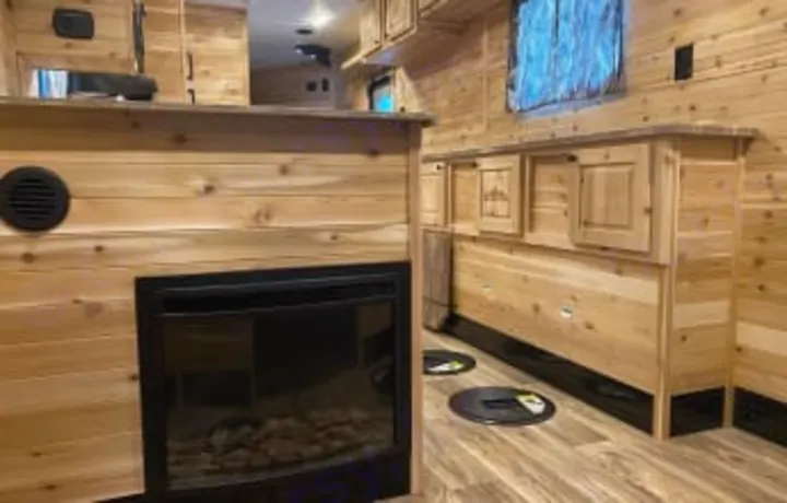 This cozy ice fishing house interior, perfect for an RV rental, features a fireplace and multiple fishing holes.. Glacier Ice House Glacier Ice House Trailer 2019