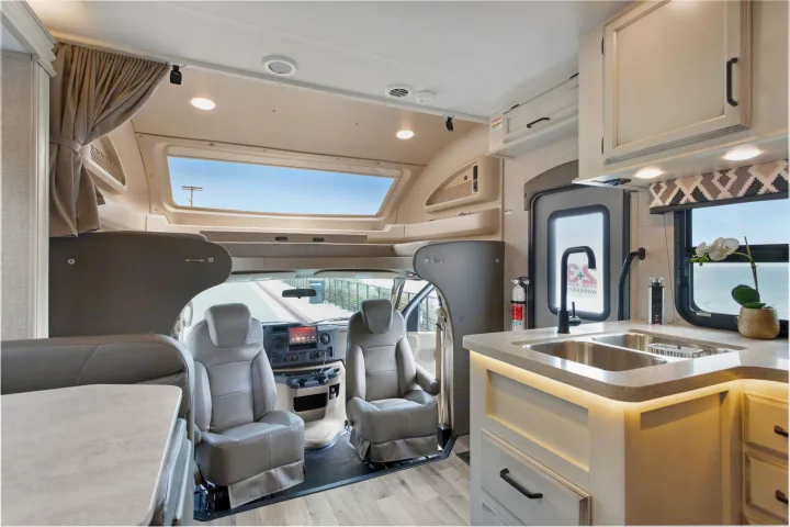 Spacious RV rental interior featuring a modern kitchen, comfortable cockpit, and an overhead cab-over bed for travel comfort.. Other Other 2022