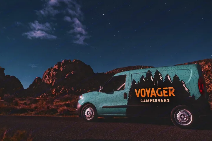 This unique Voyager Campervans **rv rental** is parked under a starry night sky, with mountains in the background.. Dodge Promaster City 2021