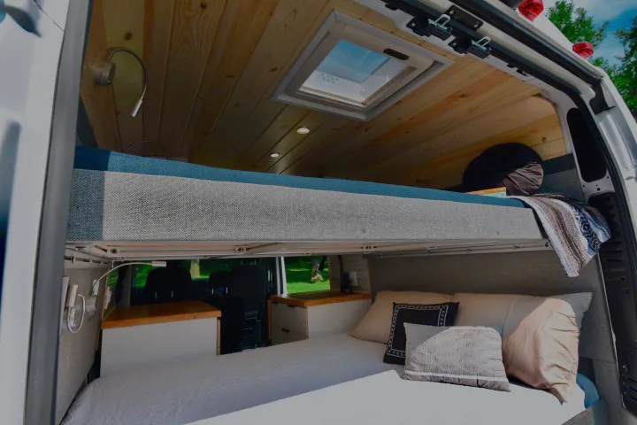 Inside an **rv rental** with cozy bunk beds, a wooden ceiling, a skylight, and reading lights.. Dodge Dodge Promaster 2500 2021
