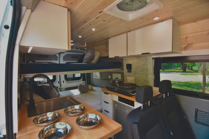 Inside a well-equipped RV rental: multi-level bed, compact kitchen, and storage for your next adventure.. Dodge Dodge Promaster 2500 2021
