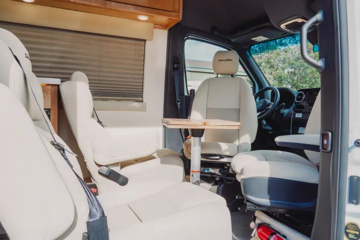 Experience comfort in this luxury RV rental. Features plush cream seating, a portable table, and a clean, inviting interior.. Forest River Coachmen Galleria 2021