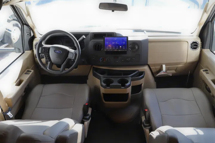 Spacious Ford RV rental cockpit featuring a clear dashboard, modern Sony display, and comfortable seating arrangements.. Entegra Coach Odyssey 2021