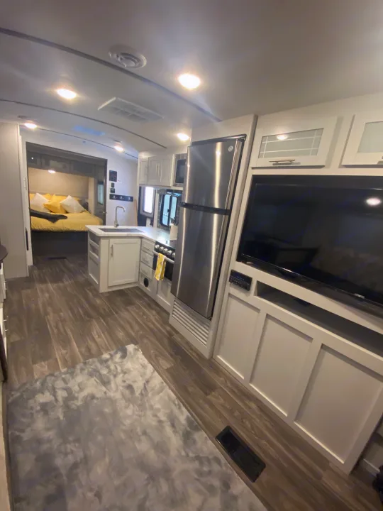 Experience comfort in this modern RV rental: a bright kitchen, cozy living area with TV, and spacious bedroom.. Keystone RV Bullet Ultra Lite 2021