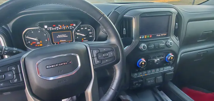 Detailed dashboard view of a GMC Denali, with steering wheel controls, digital display (24538mi), and infotainment. An ideal rv rental.. GMC Sierra 2500HD Denali 2020
