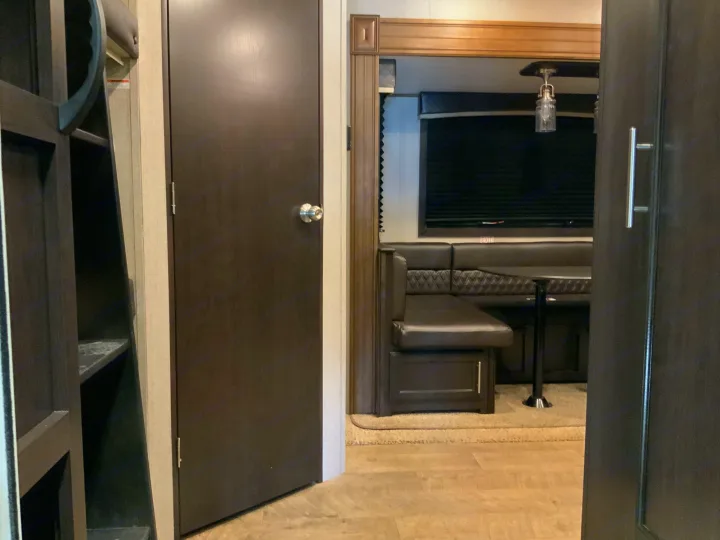 Inside this RV rental: a cozy dining booth, bunk access, and interior doors for compact living.. Jayco Eagle HT 2019
