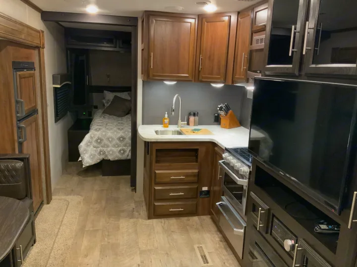 RV rental interior: modern kitchen, entertainment area, and comfy bedroom visible. Ideal for mobile living.. Jayco Eagle HT 2019