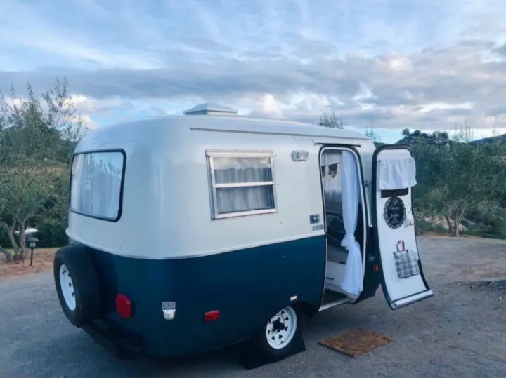 Explore in style! This charming two-toned vintage compact RV rental offers cozy travel and outdoor stays.. Scamp 13' 1979