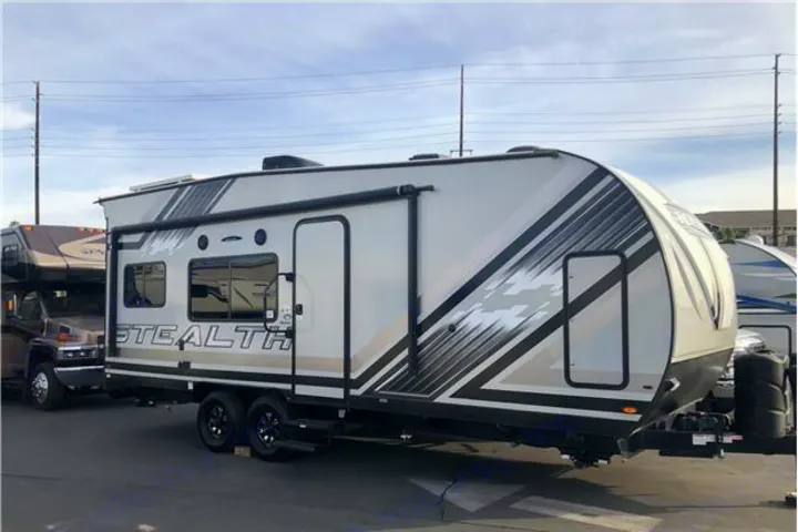 Modern Stealth RV rental travel trailer, white with black graphics, parked outside.. Forest River Stealth 2020