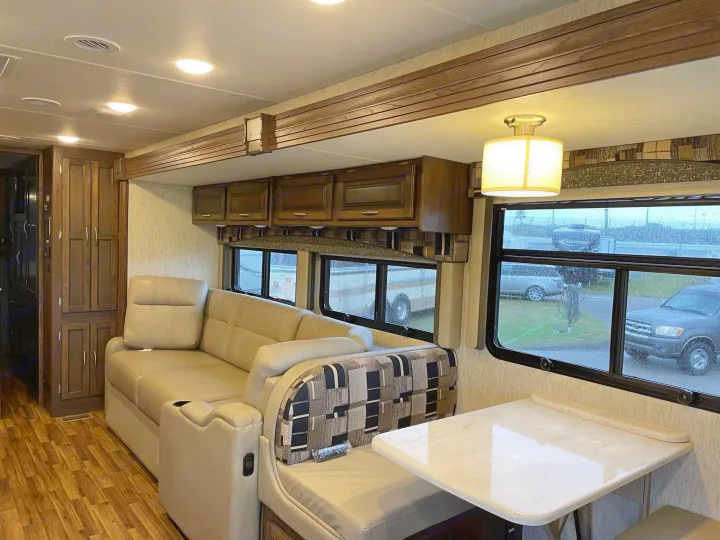 Inside an RV rental: a modern living space with a pull-out sofa, dinette, and ample storage for comfortable travel.. Coachmen Mirada 2018