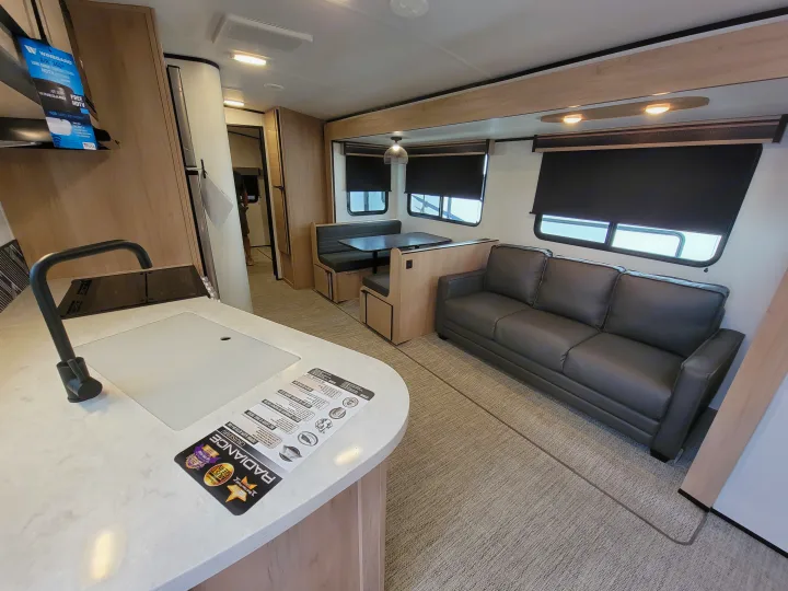 Spacious RV living area for your next rv rental, featuring a modern kitchen, comfortable dinette, and sofa.. Cruiser Rv Corp Radiance 30ds 2021