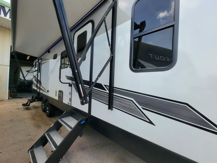 This modern white RV rental showcases its extended awning with LED lights and sturdy deployed steps for easy access.. Cruiser Rv Corp Radiance 30ds 2021