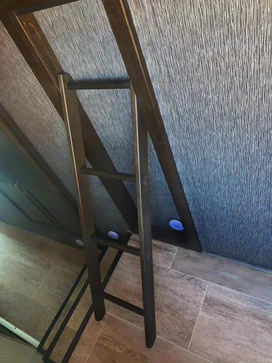 RV rental interior: angled dark wood bunk ladder, textured wall, glowing accent lights, and tiled floor.. Heartland Elkridge 2019