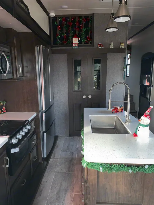 Enjoy a holiday season RV rental with this modern kitchen, featuring stainless steel appliances & cheerful Christmas decor.. Heartland Elkridge 2019