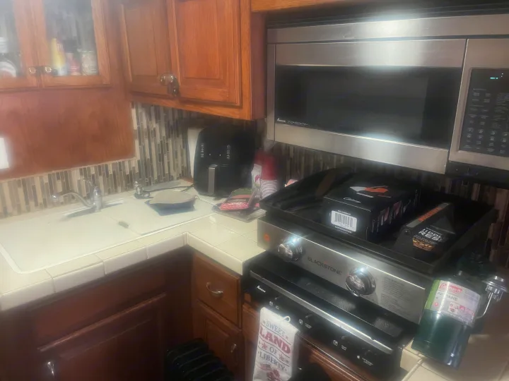 Functional RV rental kitchen with Amana microwave, sink, and a portable Blackstone griddle powered by propane.. Airstream Skydeck 2008