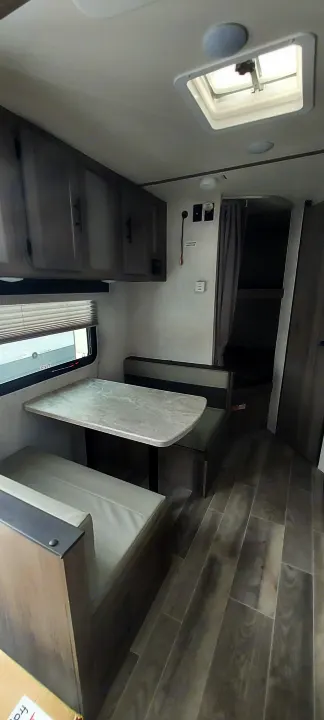RV rental interior: bunk beds, dinette, window, and wood-look flooring. Ideal for your next adventure!. Amerilite 197BH 2021