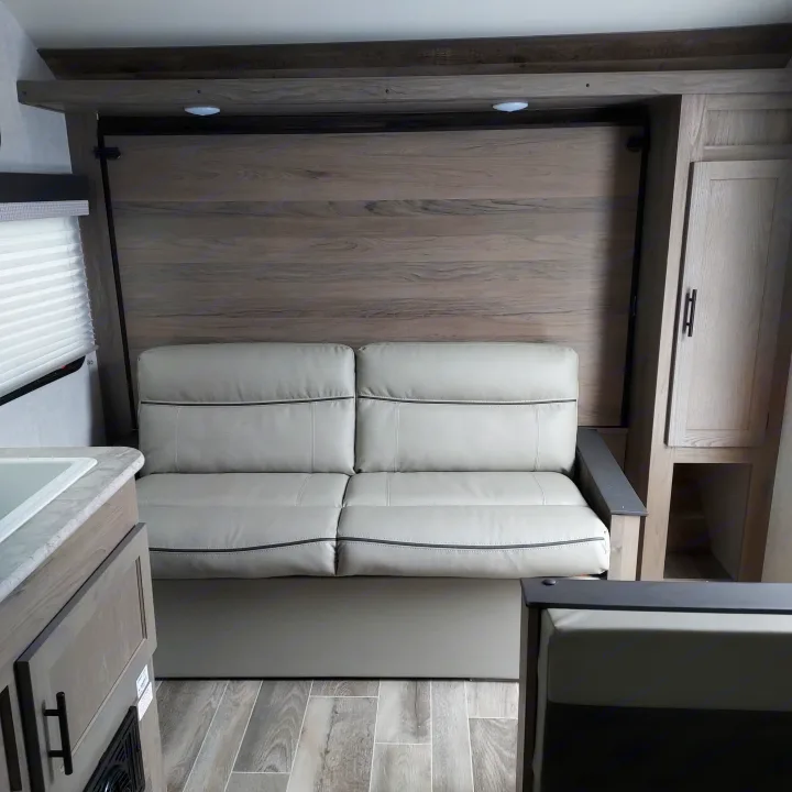 RV rental: light wood interior with a versatile fold-down bed/sofa & compact kitchenette. Smart space design.. Amerilite 197BH 2021