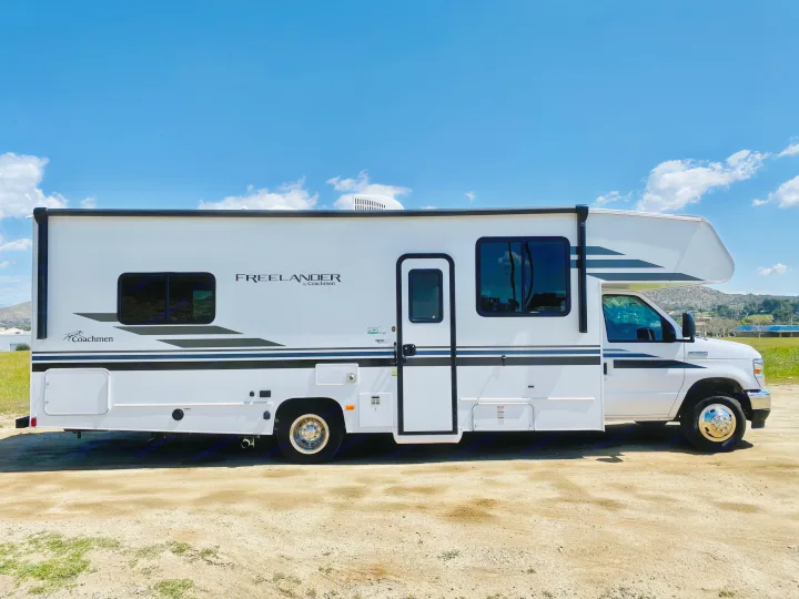 White Coachmen Freelander RV rental, perfect for adventures. Parked on a sunny day with blue skies.. Coachmen Freelander 2021