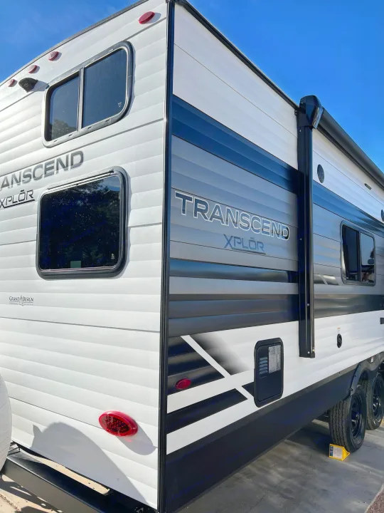 Side and rear view of a white and black Transcend Xplor travel trailer, perfect for your next RV rental adventure.. Grand Design Transcend Xplor 240BH 2022