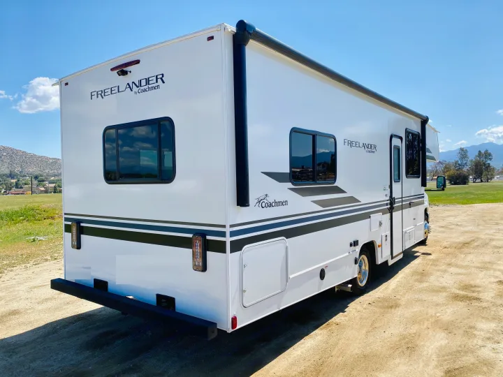 A pristine white Coachmen Freelander RV rental sits ready for adventure in a sunny outdoor setting.. Coachmen Freelander 2021