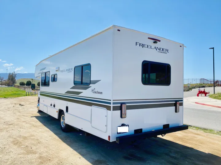 Rear-side view of a white Coachmen Freelander rv rental. This spacious motorhome is ready for your next travel adventure.. Coachmen Freelander 2021